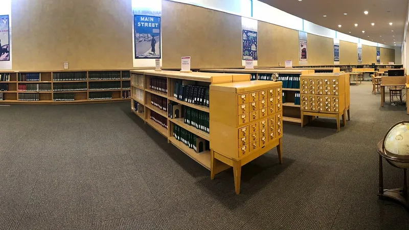Sala di lettura della biblioteca con scaffali bassi e schedari in legno