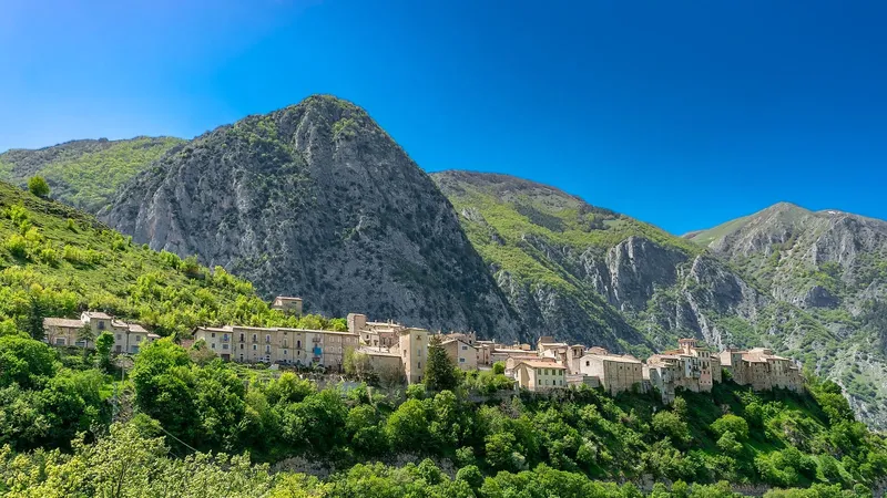 Case del borgo allineate sul crinale, con le montagne sullo sfondo