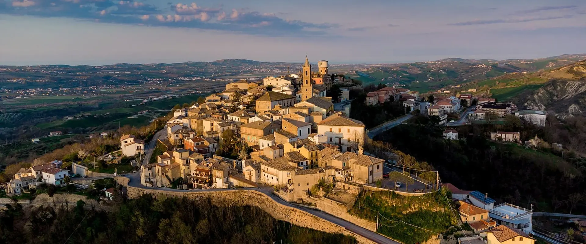 Il borgo sul colle visto dall’alto, con le case in pietra raccolte attorno alla chiesa