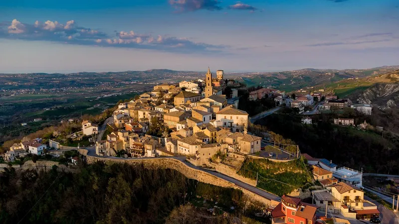 Il borgo sul colle visto dall’alto, con le case in pietra raccolte attorno alla chiesa