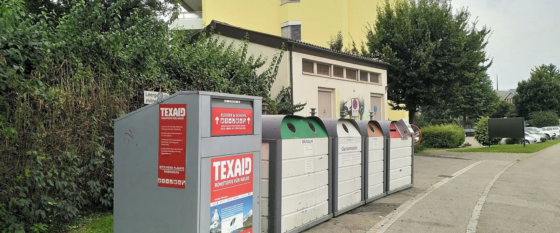 Contenitori per la raccolta differenziata in un’area attrezzata accanto alla strada