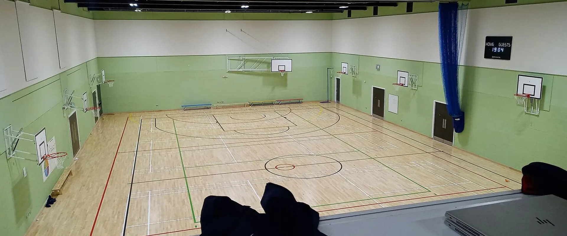 Campo da gioco del palazzetto con il parquet e i canestri