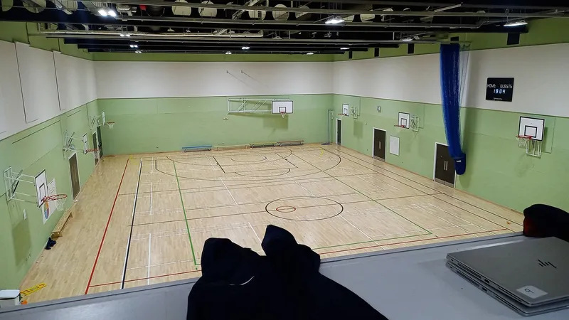 Campo da gioco del palazzetto con il parquet e i canestri